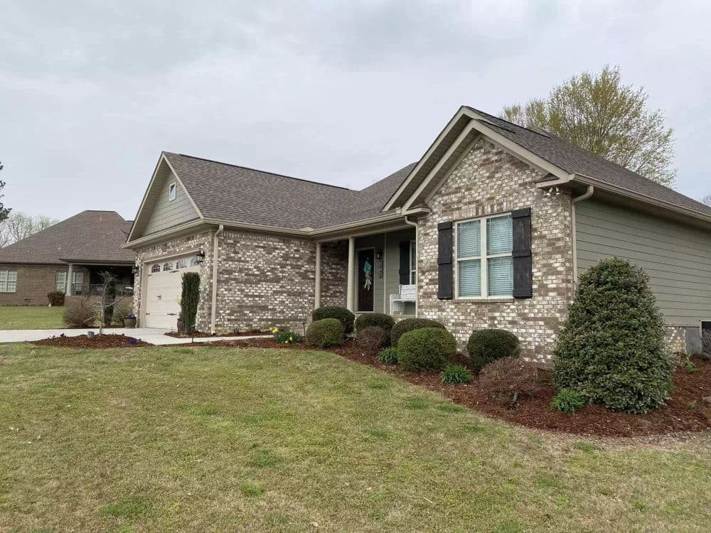 Single-story brick home with landscaped yard and garage, ideal for family living.